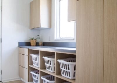 custom built laundry storage with shelving to hold laundry baskets.
