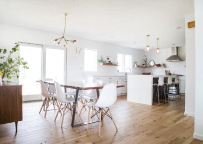 A white kitchen featuring gold hardware and open shelving.