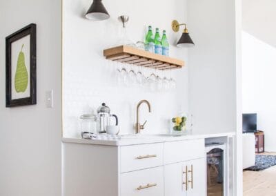 A custom built bar. featuring all white and gold hardware.