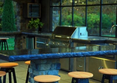 A beautiful custom built patio that includes a bar, grill, and sink.