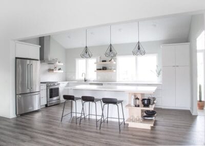 A chic custom built home featuring cool wood floors and white walls for contrast. This home has an open concept floor plan between the kitchen and living room.