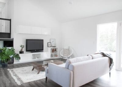 A chic custom built home featuring cool wood floors and white walls for contrast. This home has an open concept floor plan between the kitchen and living room.