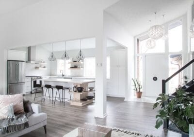 A chic custom built home featuring cool wood floors and white walls for contrast. This home has an open concept floor plan between the kitchen and living room.