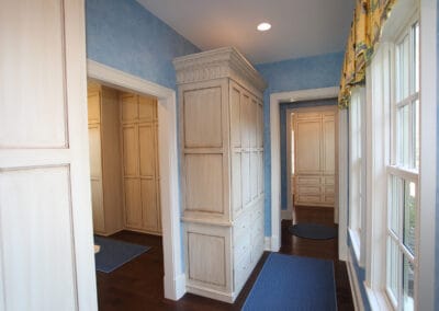 A custom built home featuring light blue hallway which white doorframes and window frames.