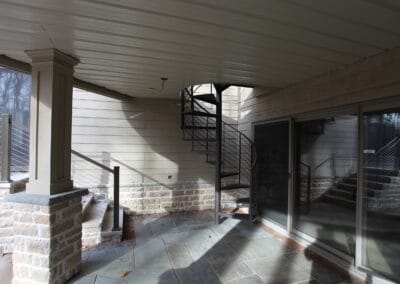 A spiral staircase leading from a patio to a deck.