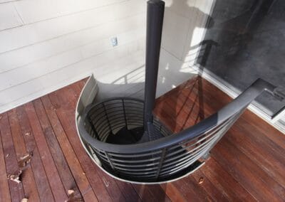 Spiral stairs leading from a deck to a patio.