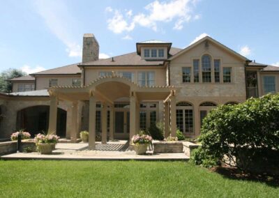 High Quality, Luxurious Custom Home featuring tan neutral stones, a large patio and pergola.