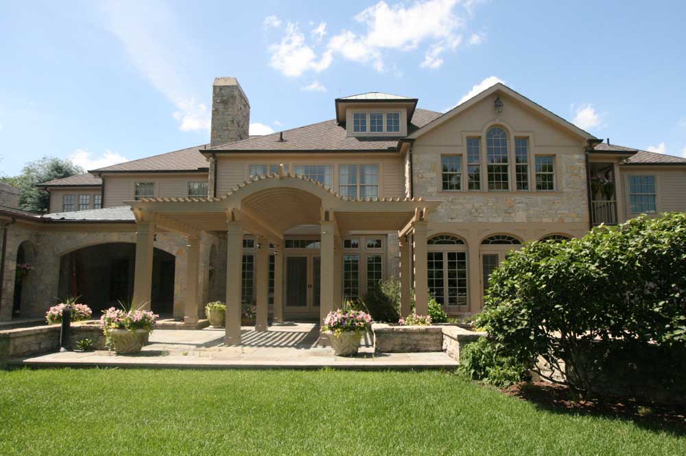 High Quality, Luxurious Custom Home featuring tan neutral stones, a large patio and pergola.