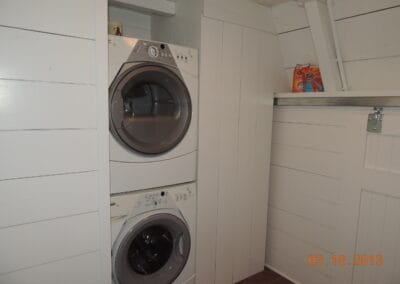 The laundry room in a custom renovated ski cabin features a white modern washer/dryer combo.