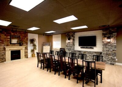 A rustic style showroom featuring stone accent walls and a natural wood dining table.