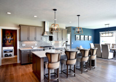 An open concept kitchen and dining room featuring a light tan kitchen with grey undertones, and a blue dining room.