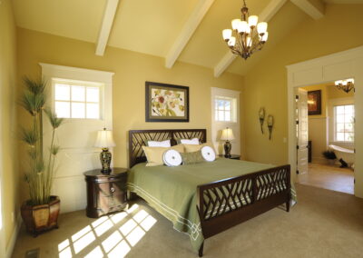 A relaxing mute yellow, and sage green bedroom with white doors, and