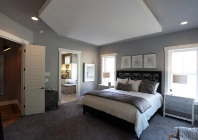 A gray master bedroom with a drop ceiling.