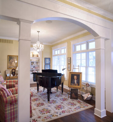 A living room featuring pale yellow walls, with red & yellow plaid chairs.