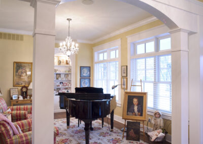 A living room featuring pale yellow walls, with red & yellow plaid chairs.