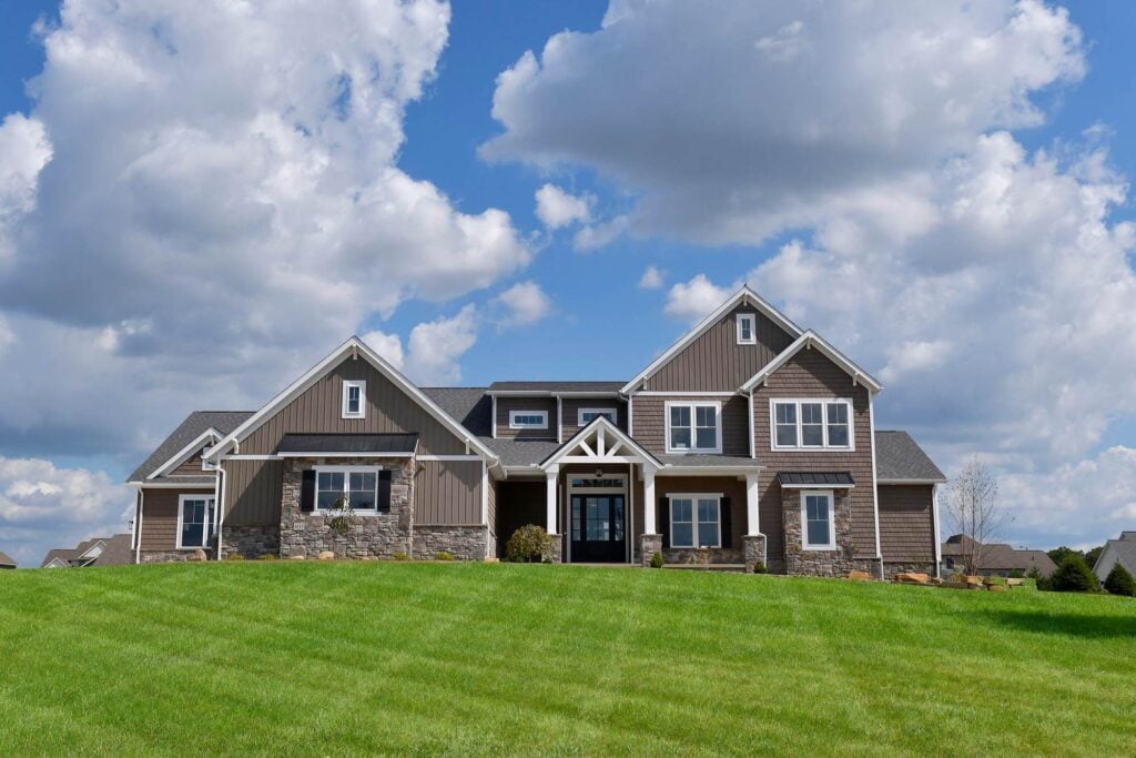Modern Farmhouse exterior design with brown siding and neutral stones.