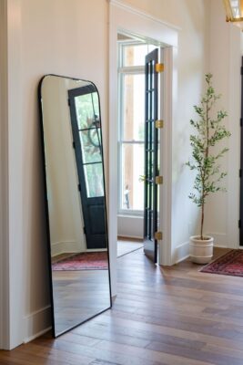 Create an elegant feeling in your foyer with a stand up mirror, french doors, and a tall indoor plant.
