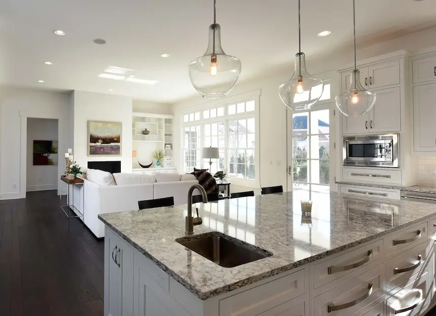 Beautiful open layout white cabinet kitchen with granite counter tops and living space